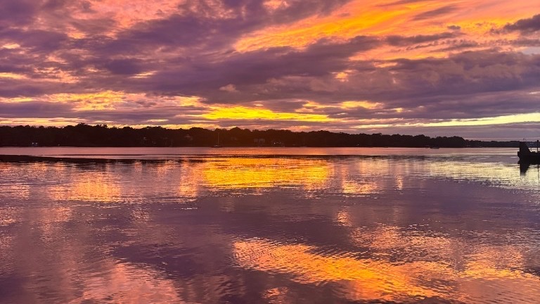 Sunset over water — purple sky mirrored in the bay
